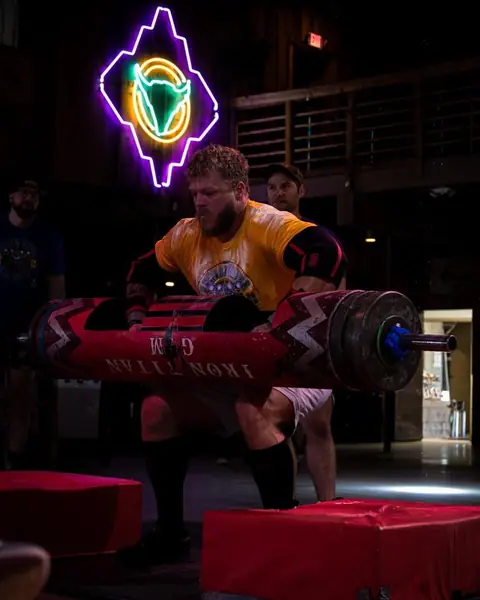 Iron Warrior athlete lifting a strongman log in competition