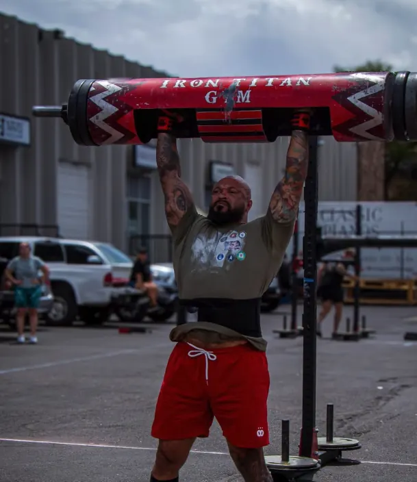 Athlete pressing an Iron Warrior strongman log